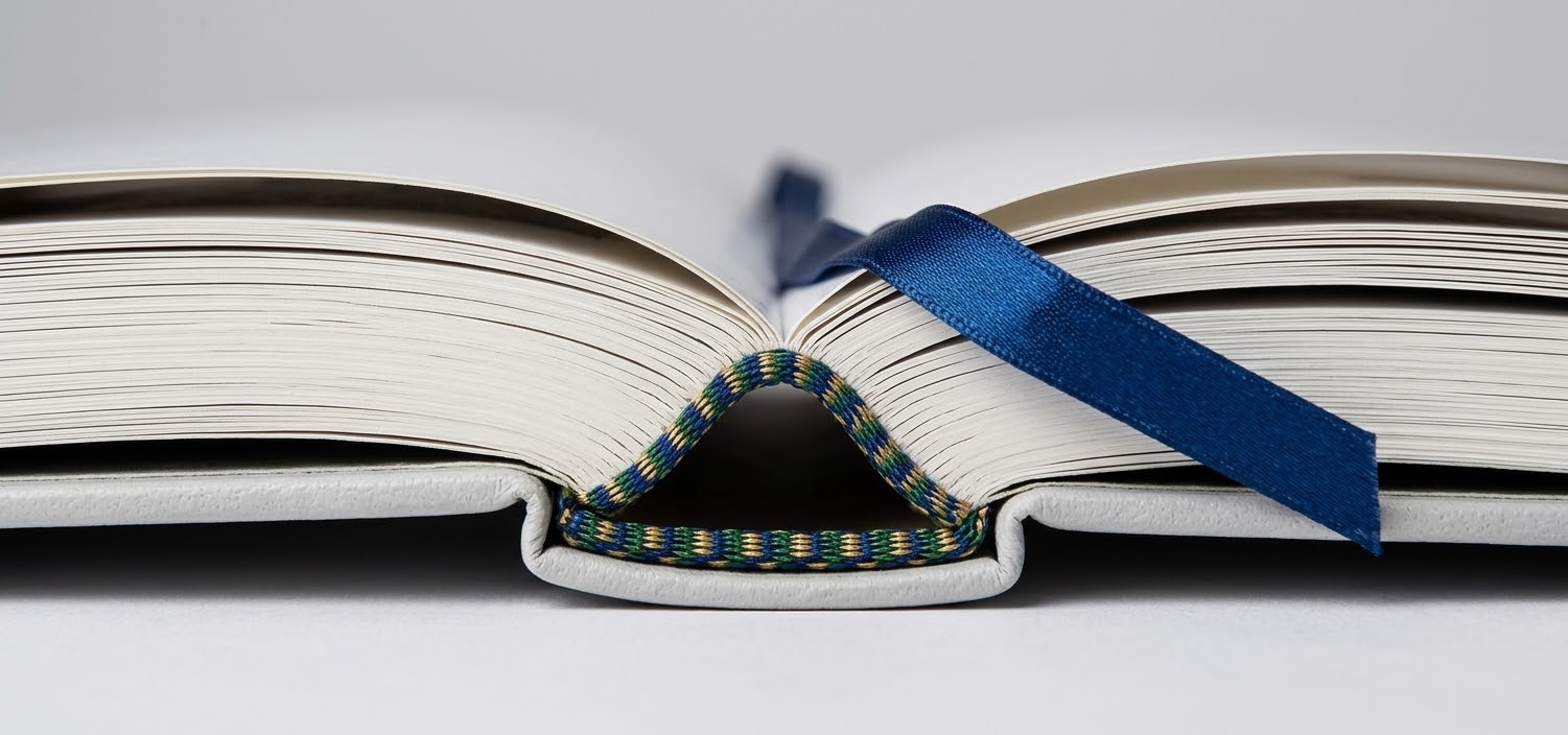 Open hardback showing a woven head and tail band where the pages meet the spine